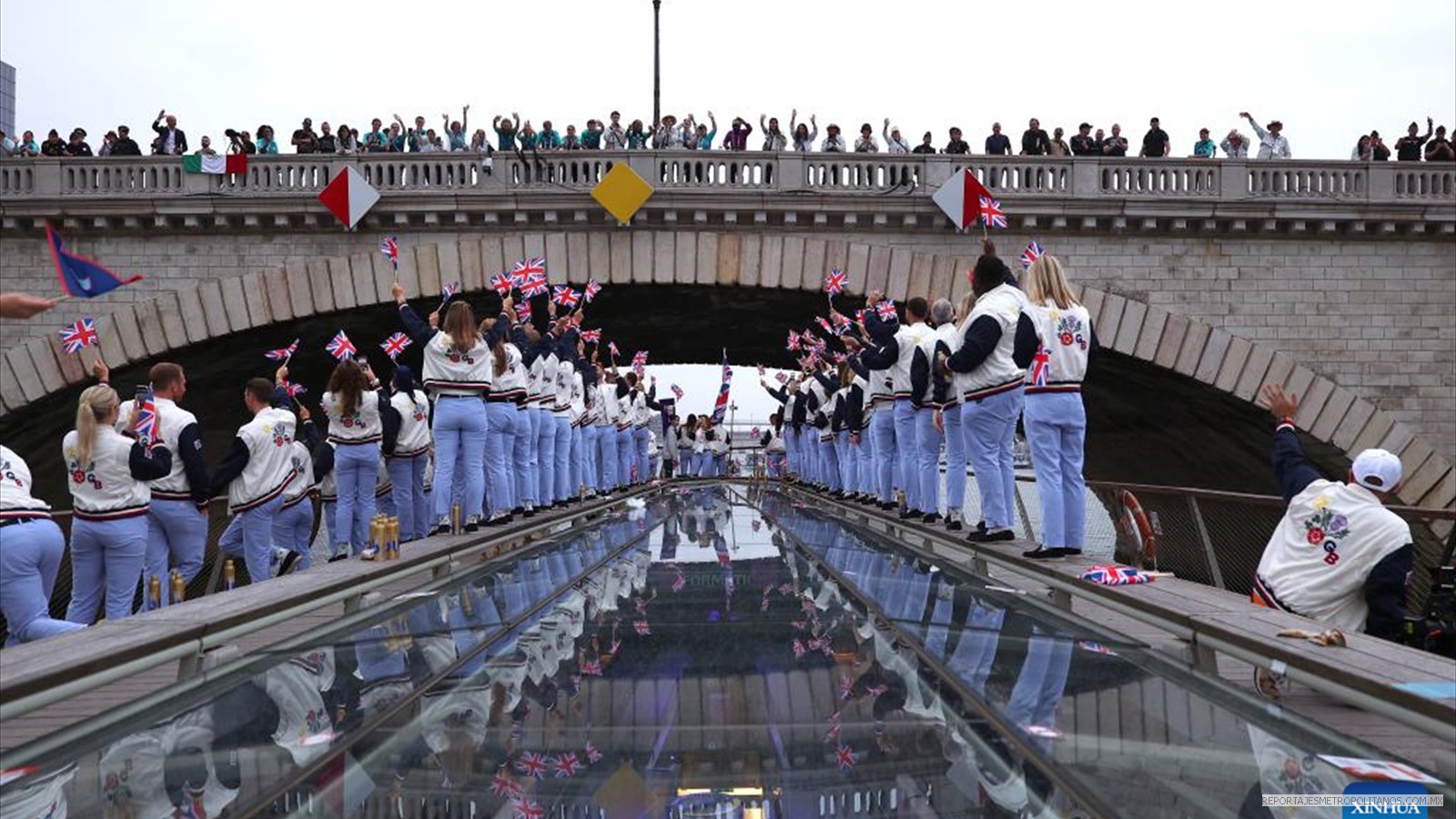 Los espectadores aplauden cuando los atletas del equipo de Gran Bretaña pasan por debajo de un puente durante la ceremonia de apertura de los Juegos Olímpicos París 2024
