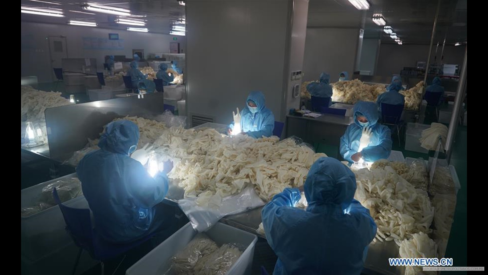 Los trabajadores revisan guantes médicos estériles en un taller de una compañía de productos de látex en Nanjing, provincia de Jiangsu