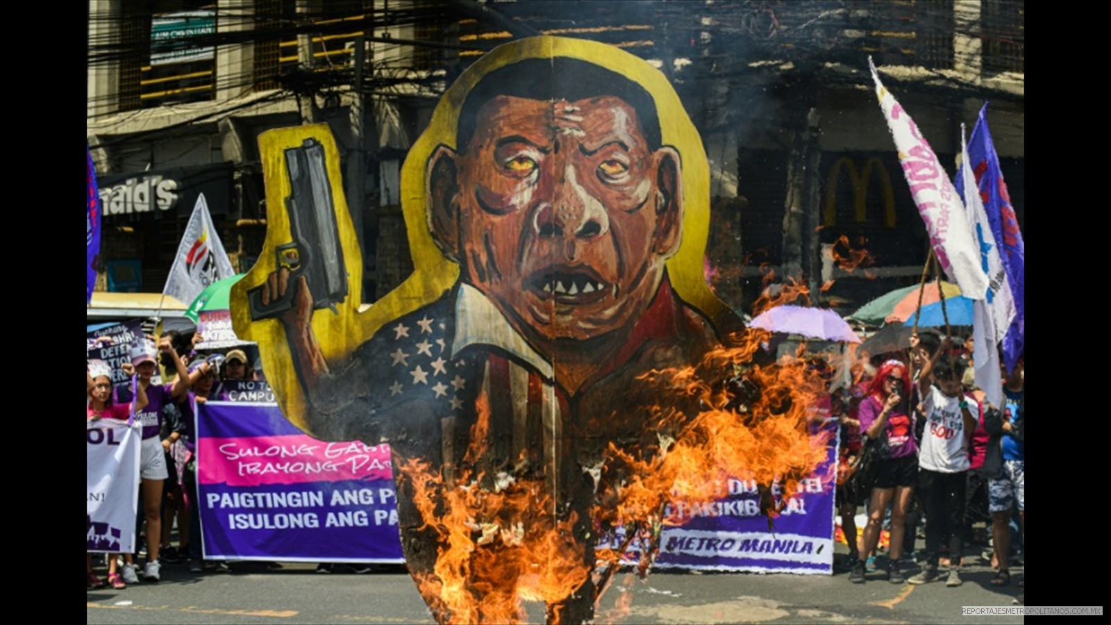 Mujeres queman una pancarta con el rostro del presidente filipino Rodrigo Duterte,  que tildan de misógino en Manila